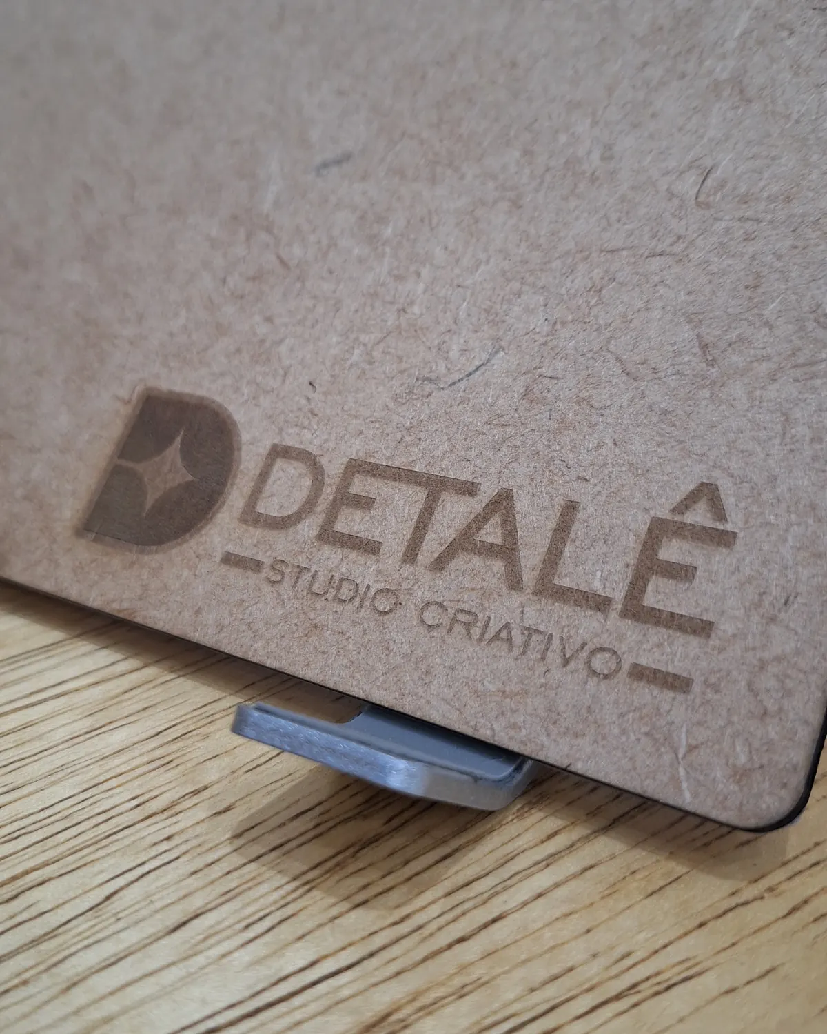 Logotipo da DETALÊ gravado a laser numa placa de MDF